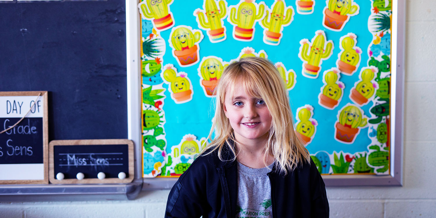 Smiling student in a classroom.